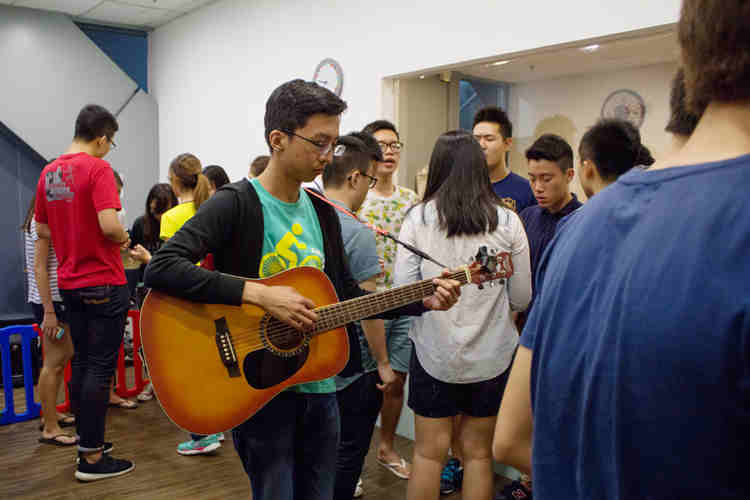 Creating the atmosphere: One of our leaders, Ming Rong, playing the guitar during the Pre-BMI prayer
